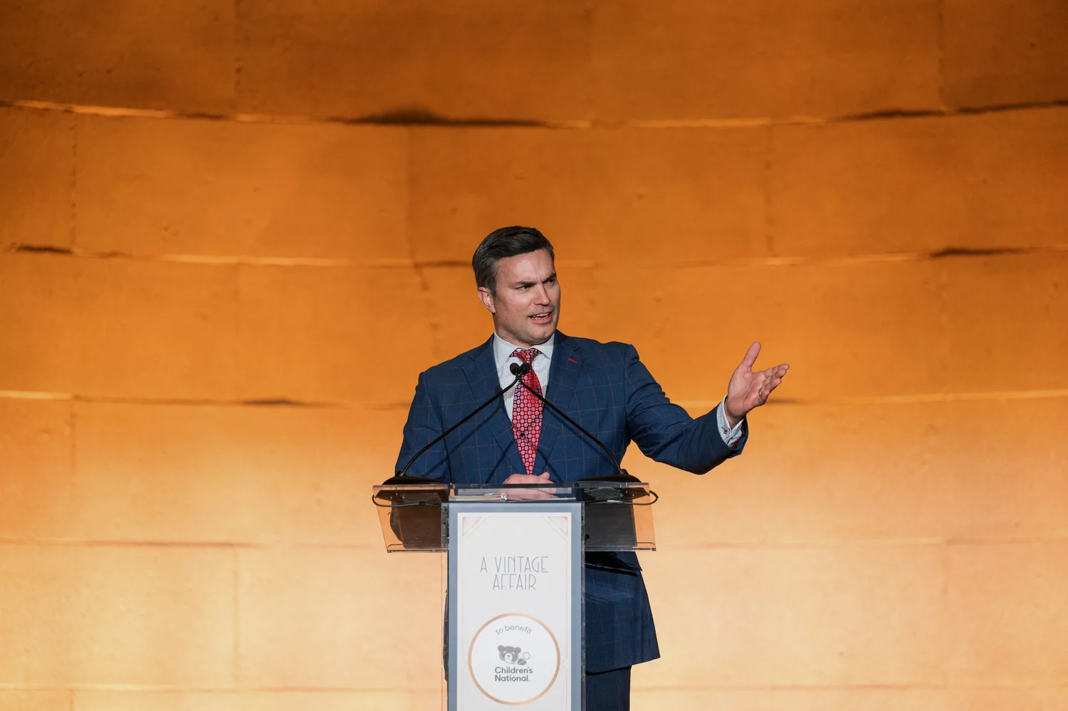 A guest speaker addresses guests from a podium during the A Vintage Affair 2025 event at the Mellon Auditorium in Washington, D.C.