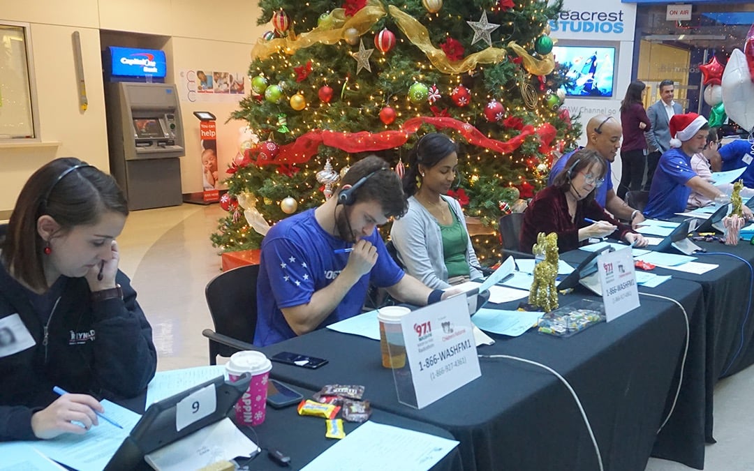 Volunteers at a registration table during a radiothon event.