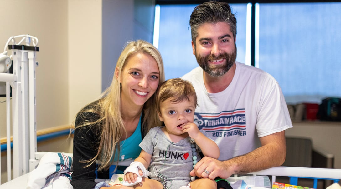 Two White parents, a woman and a man, with their baby boy.