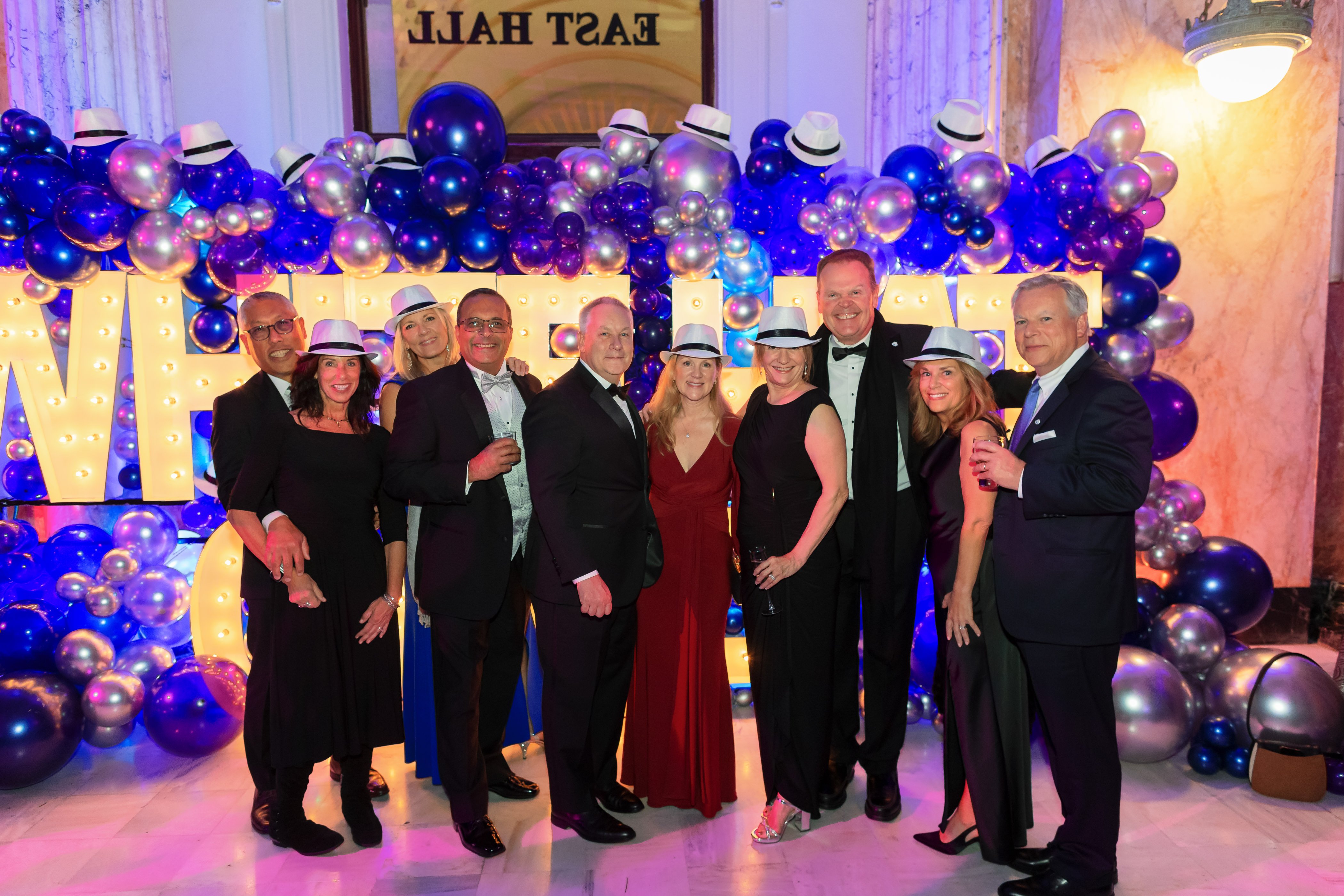 White Hat Gala 2024 attendees smiling while in front of a large balloon display