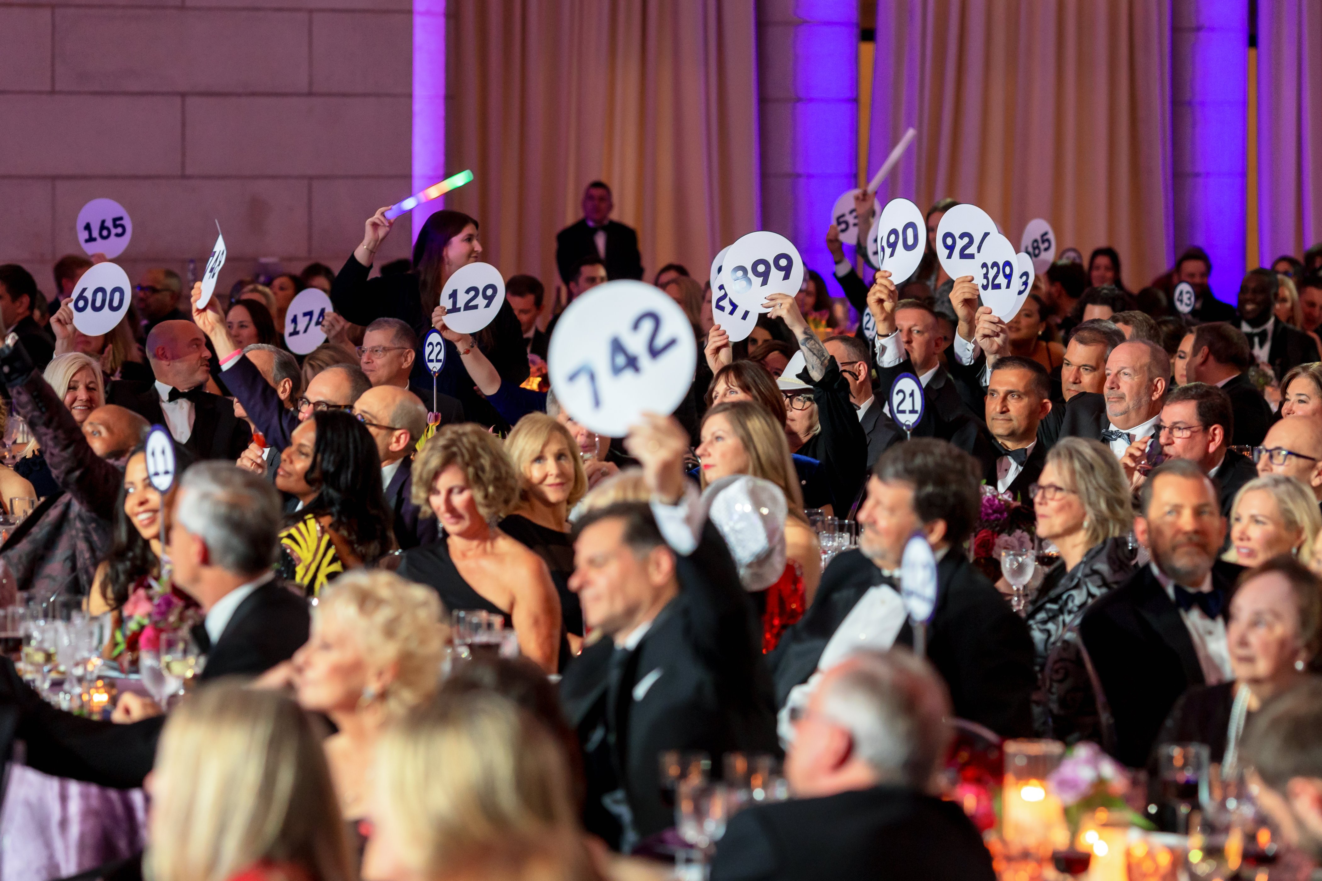 White Hat Gala 2024 attendees waving auction paddles