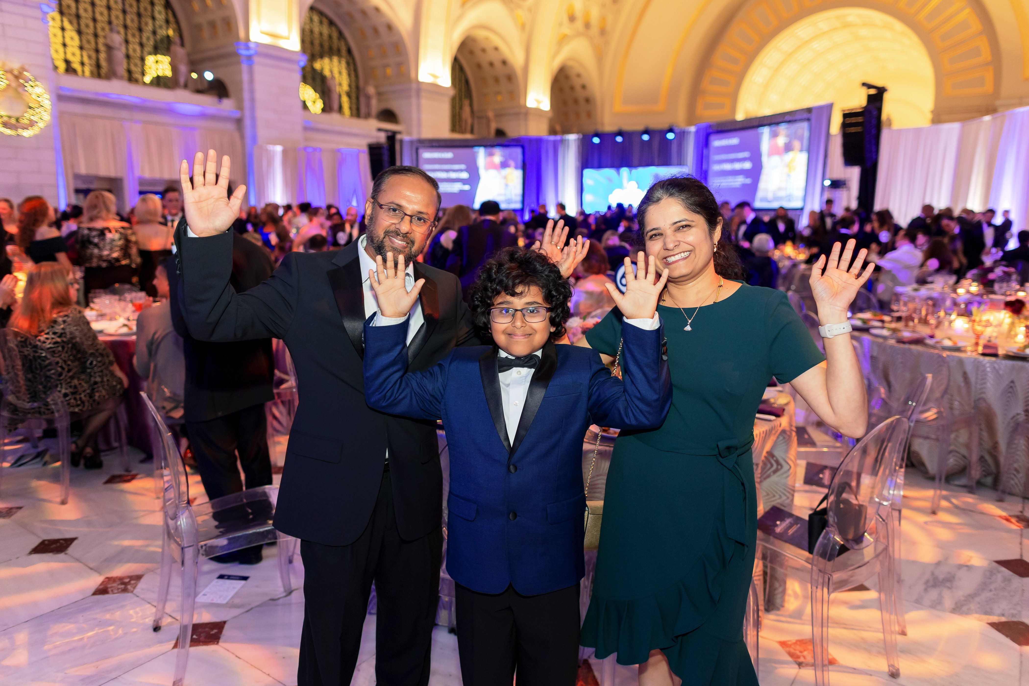 Sumukh and his family smiling and waving while at the White Hat Gala 2024