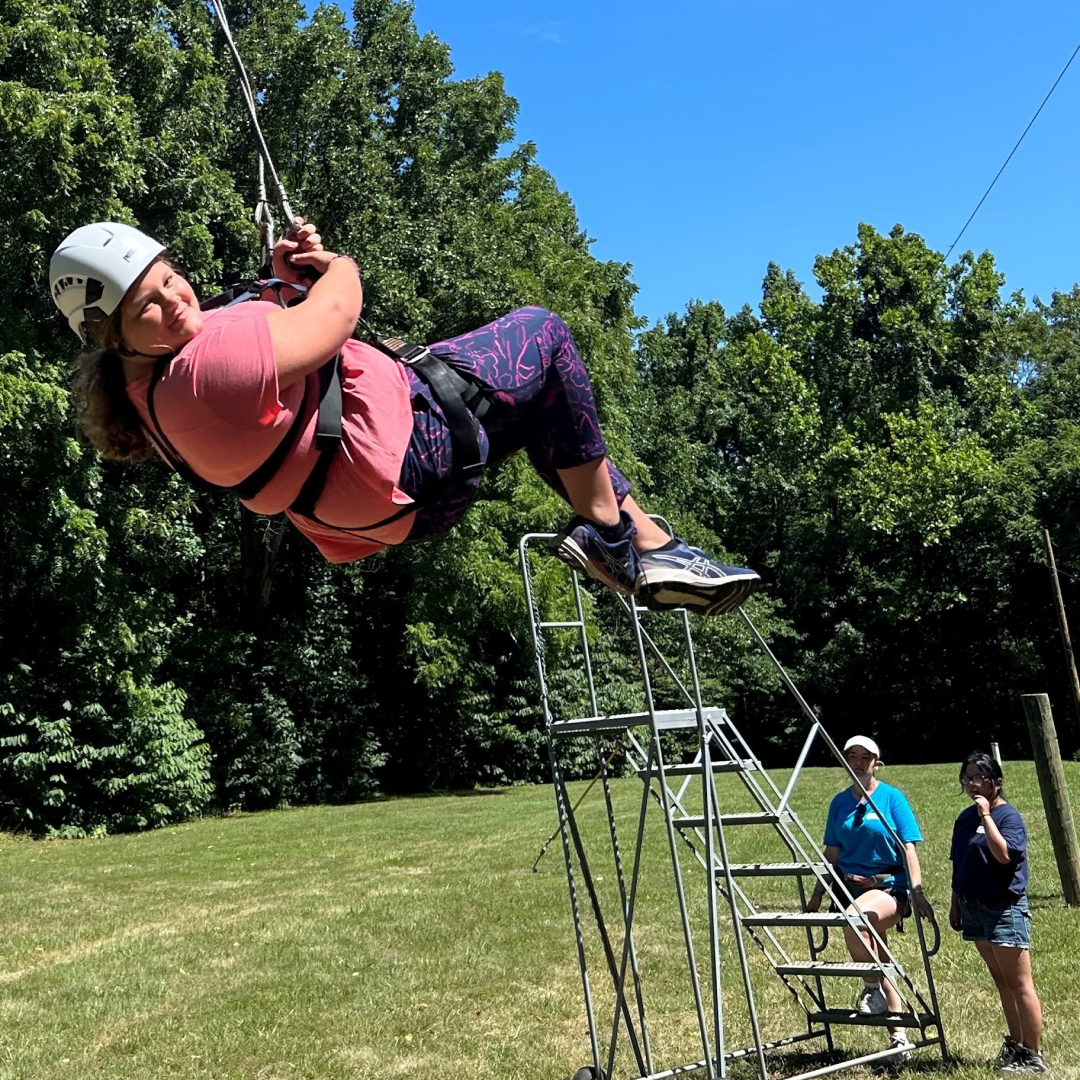 Morgan, age 12, swinging from a zipline.