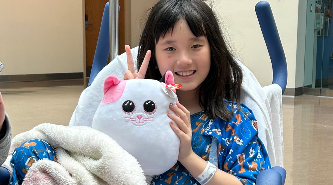 Patient Lucie with her stuffed animal, Barnard, on the way to surgery