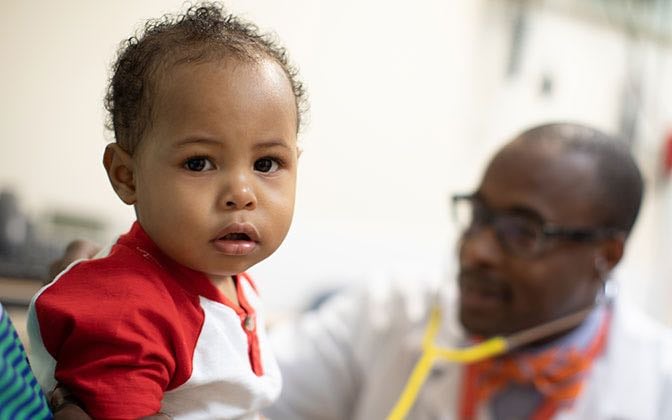 A doctor examines a young sickle cell patient.
