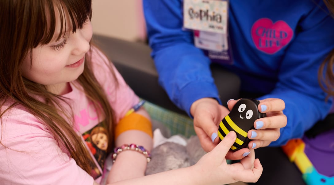 Young girl playing with a bee toy