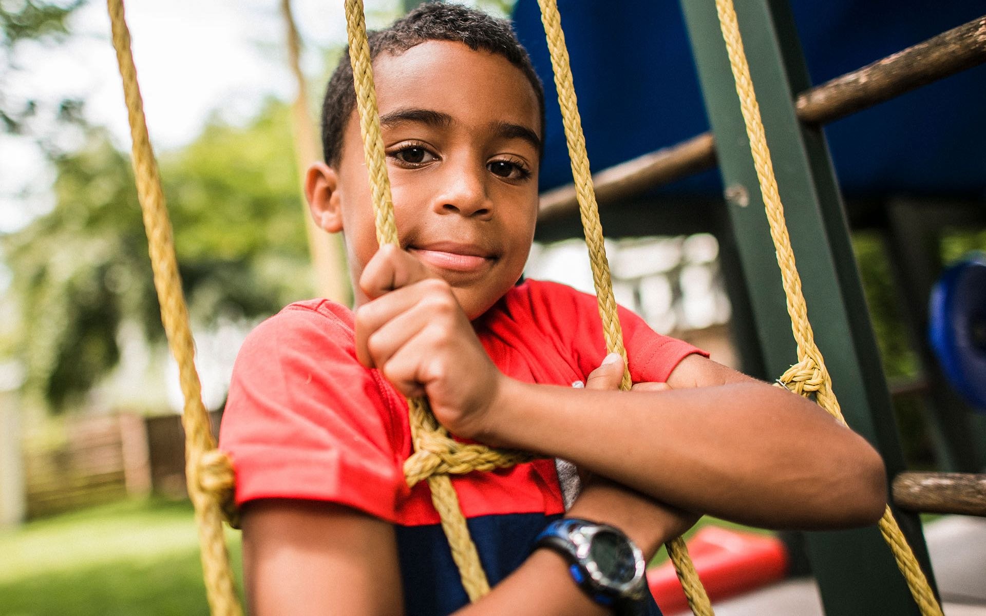 A grade school patient on a swing at a playground.