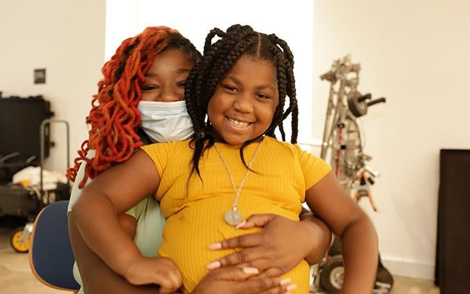 A mother holds her daughter in her lap.