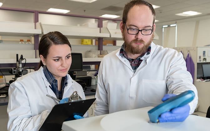 Two researchers record data.