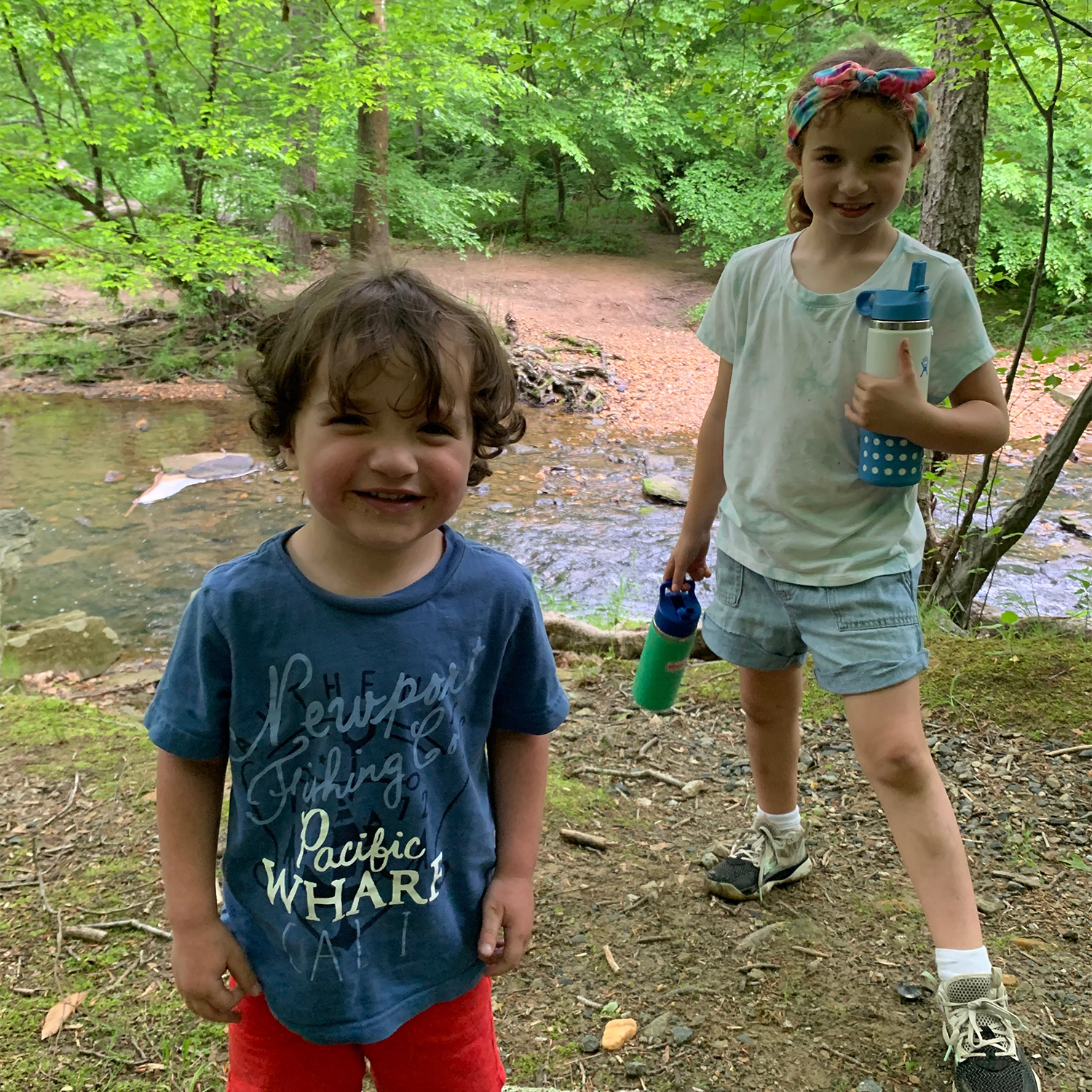 John and his sister in front of a creek