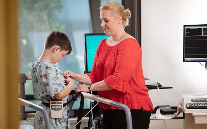 A rehab professional works with a young patient in a treatment facility.