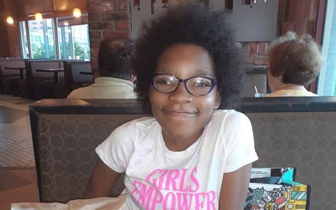 Photo of an elementary school aged patient sitting in a diner.