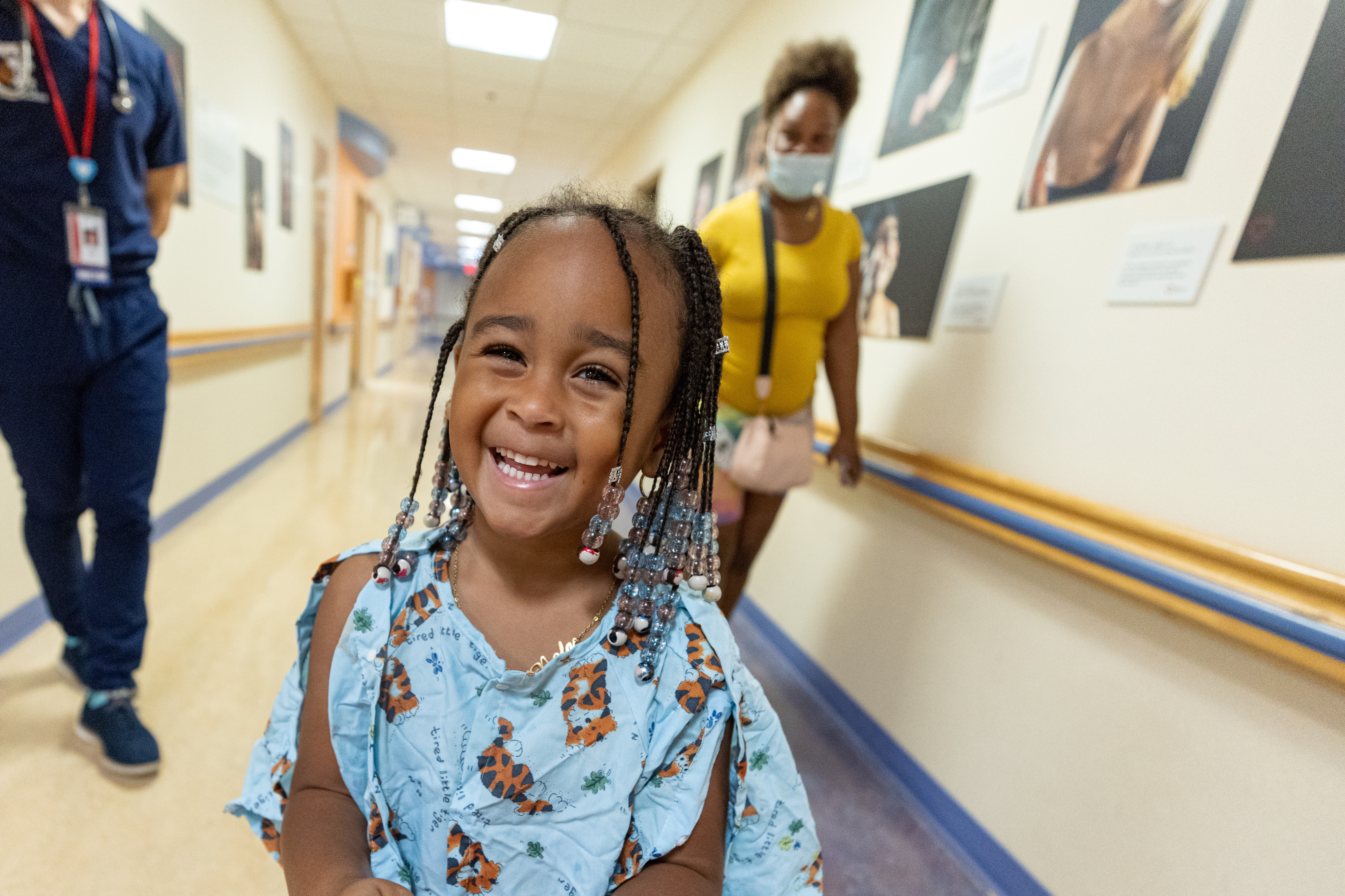 An elementary school aged Black female patient smiles in the hallway at Children't National.