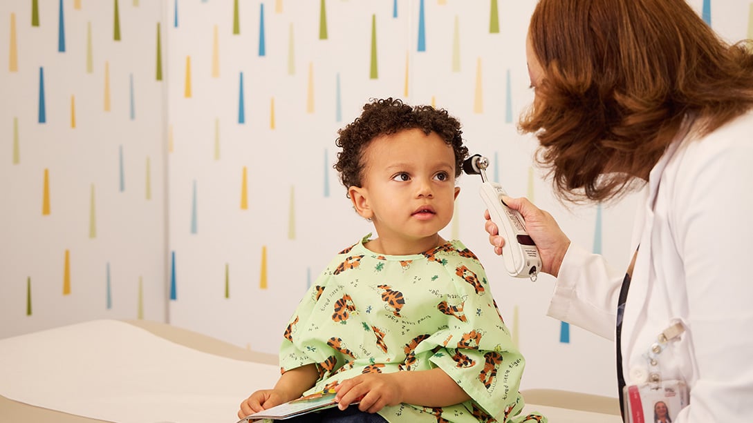 A child has their eyes examined by a health provider