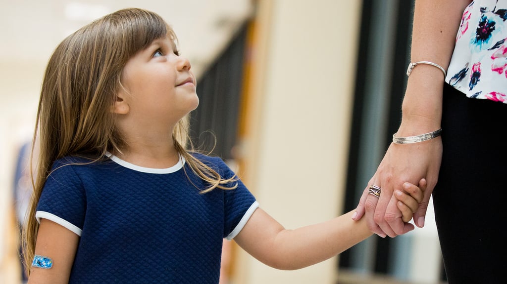 little girl holds hands with healthcare provider