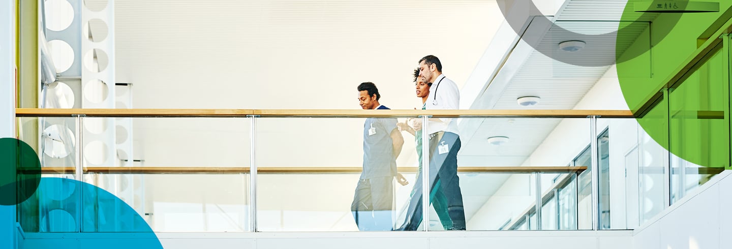 Hospital employees walking across a balcony.