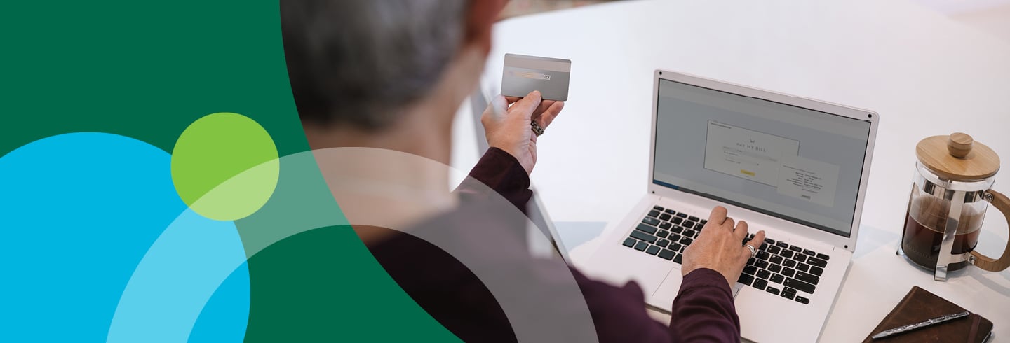 Woman entering credit card information into a website displayed on her laptop.