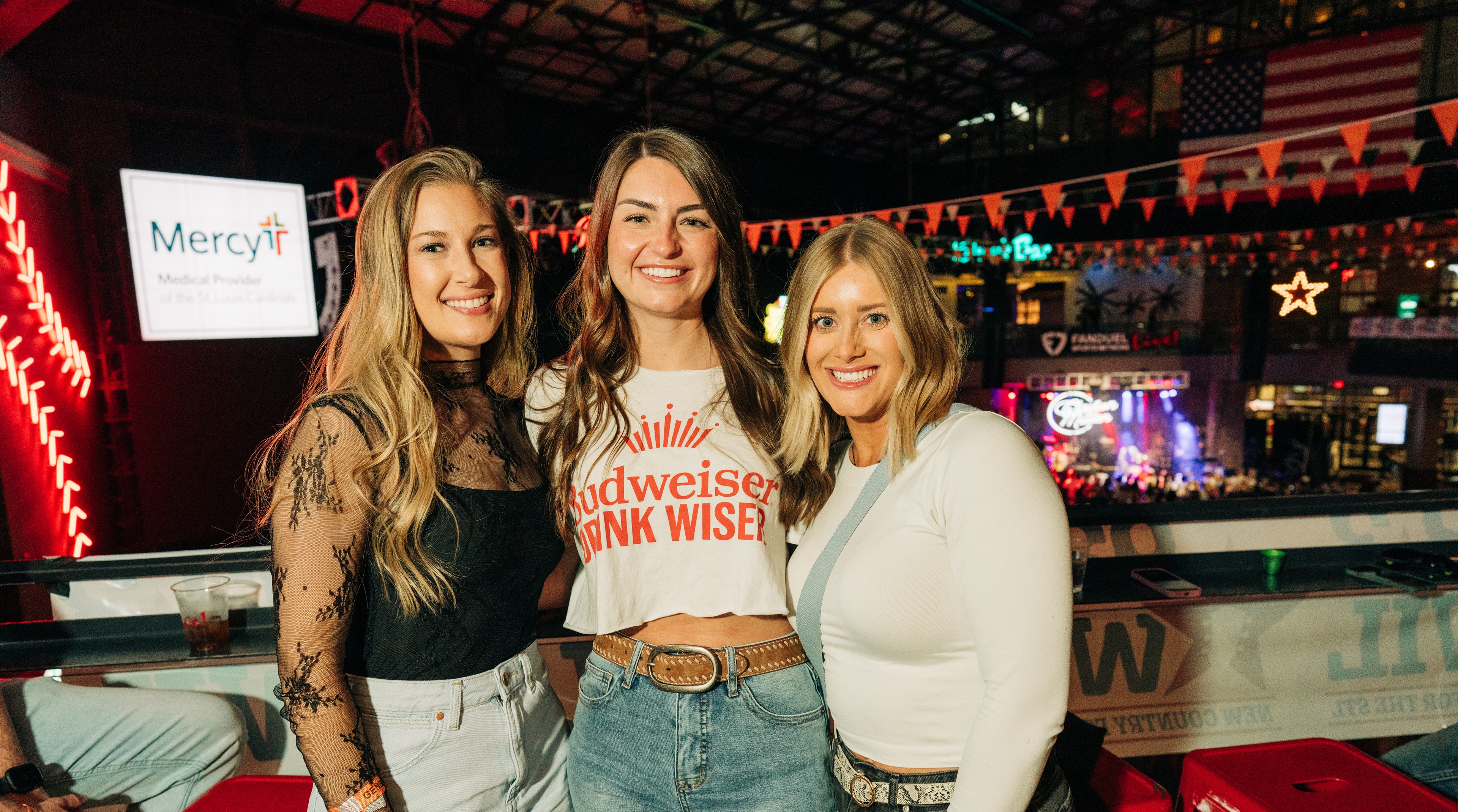 Three young women on Cardinal Nations Balcony for Hot Country Nights concert.