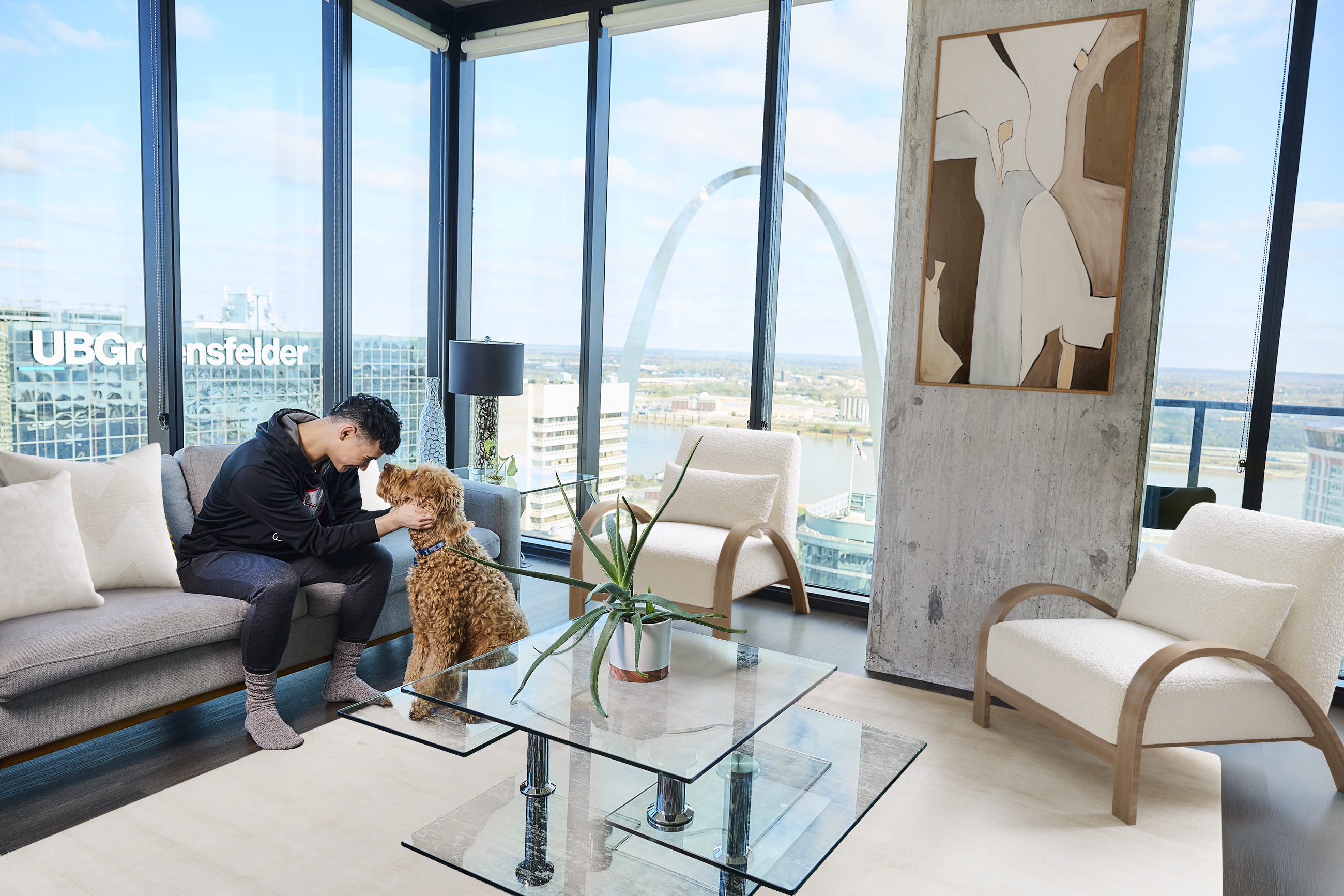 Resident sitting with his dog at a modern apartment overlooking the city