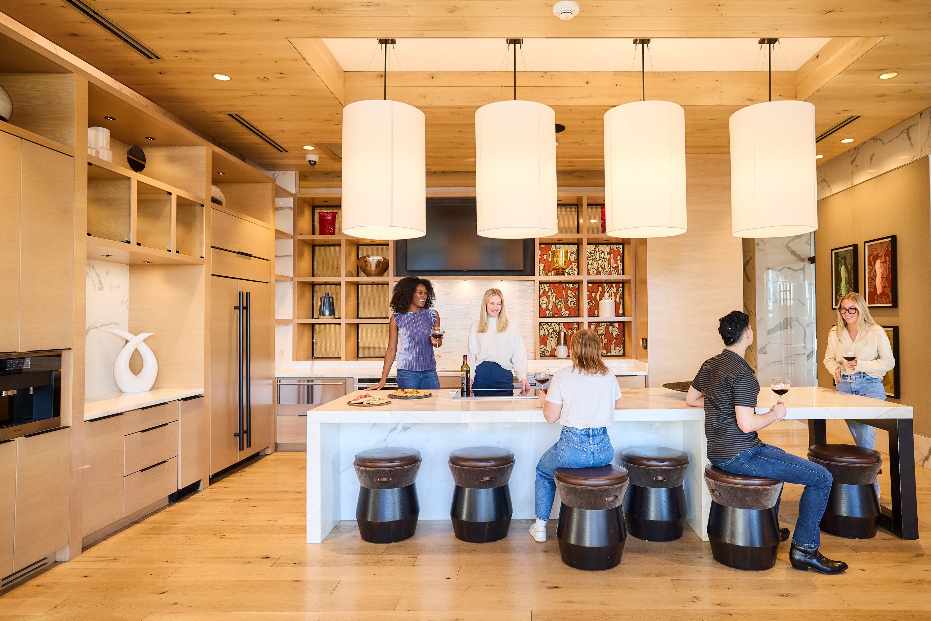 Residents enjoying a modern lounge area with drinks at One Cardinal Way