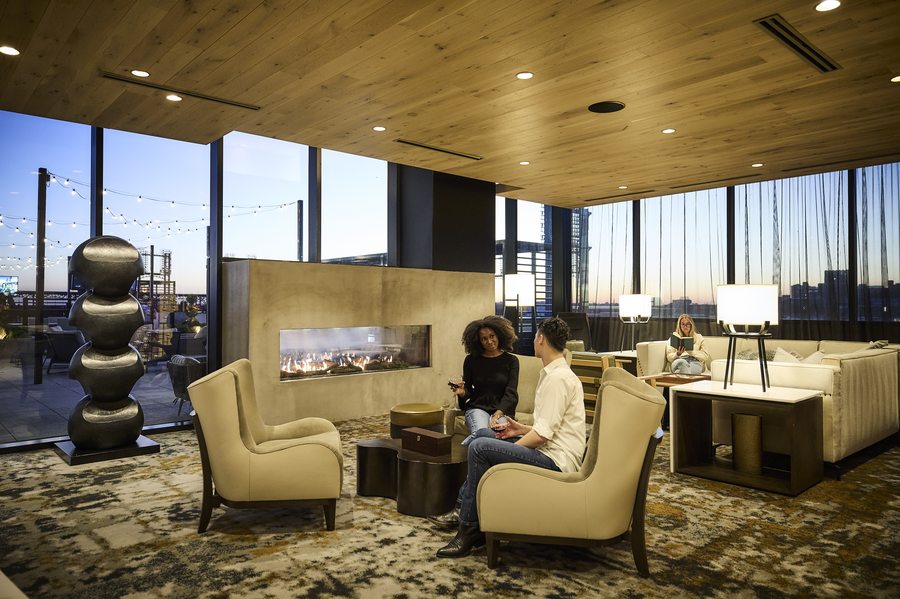 Residents enjoying a glass of wine in a modern lounge at One Cardinal Way