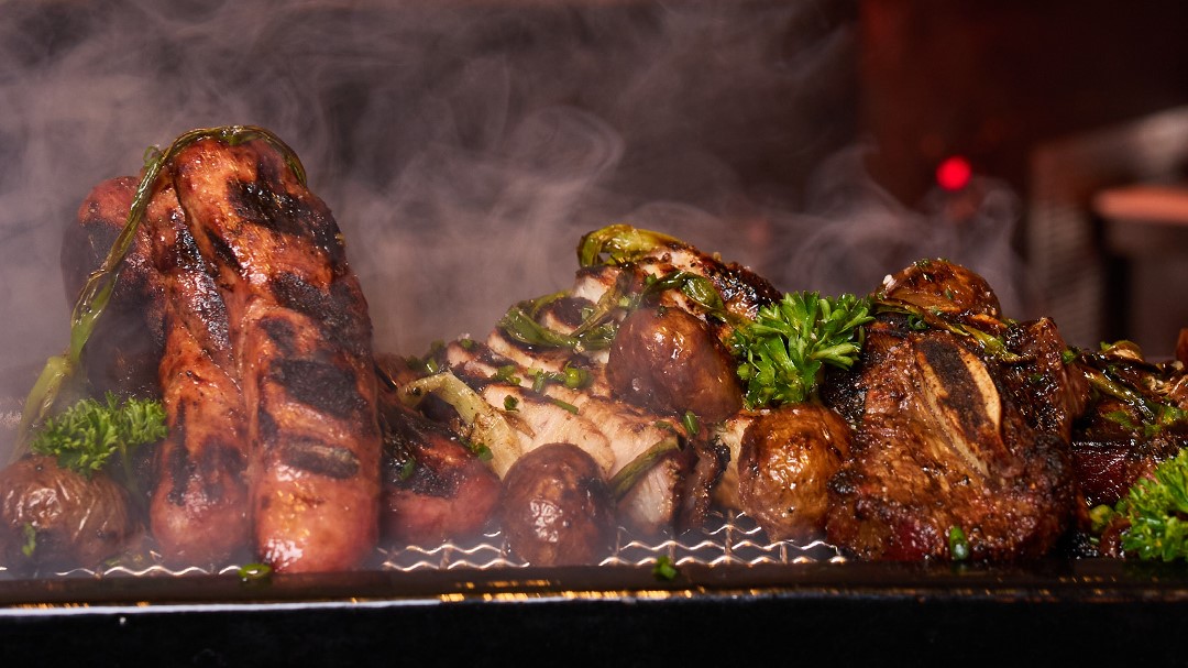 Steaming mixed grill of sausage, chicken, beef, and baby potatoes at Factoria de Azucar.