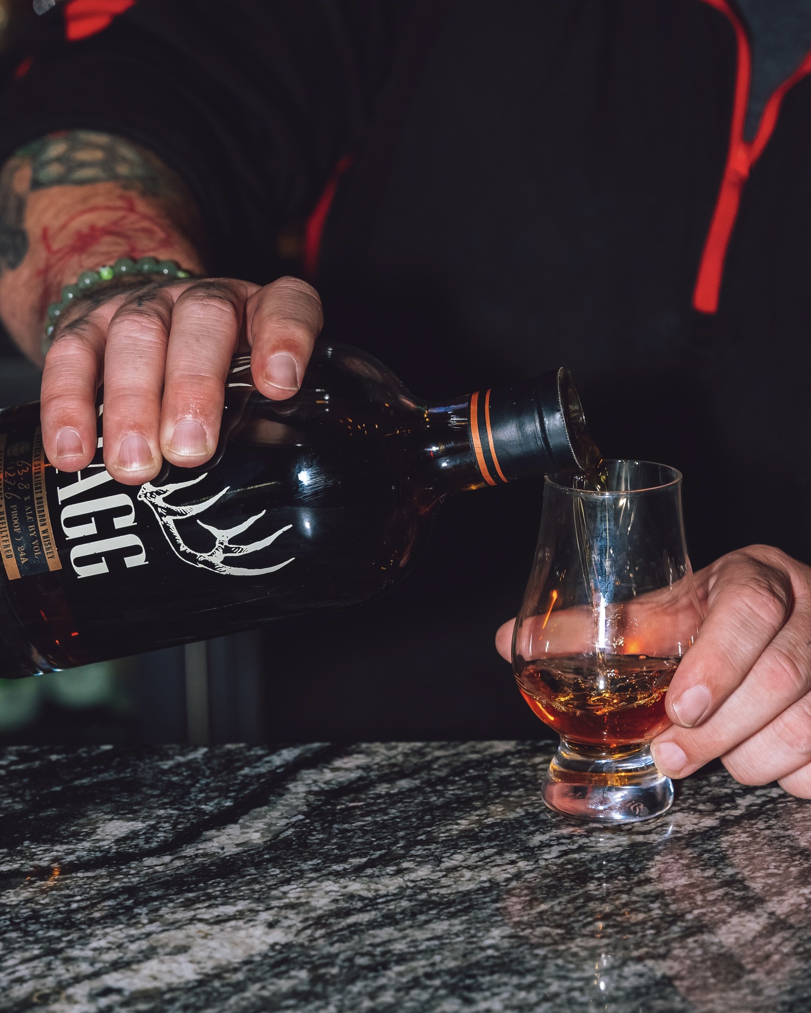 bourbon being poured at guy fieri's smokehouse