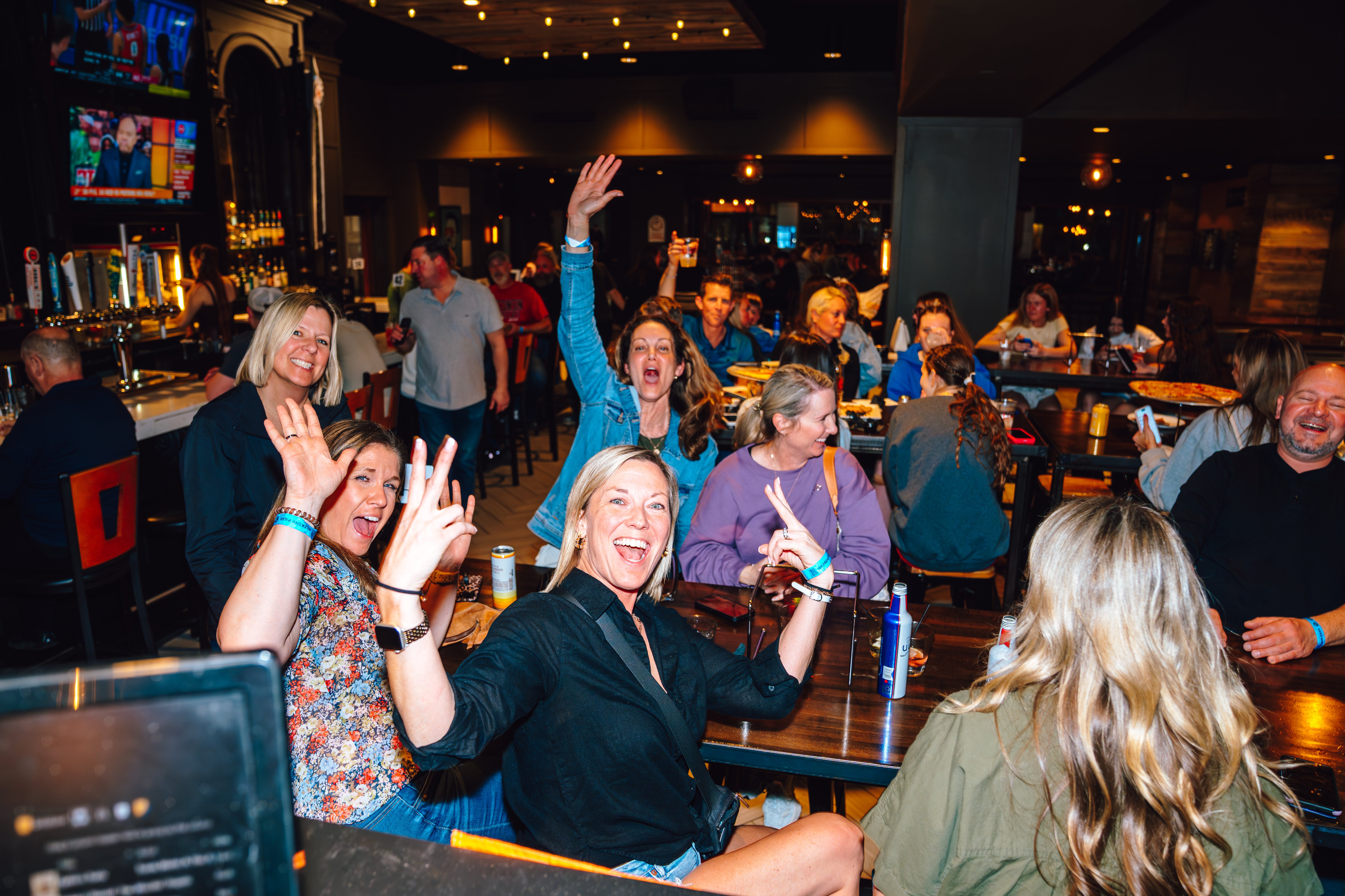 An image of a full pub and people posing.