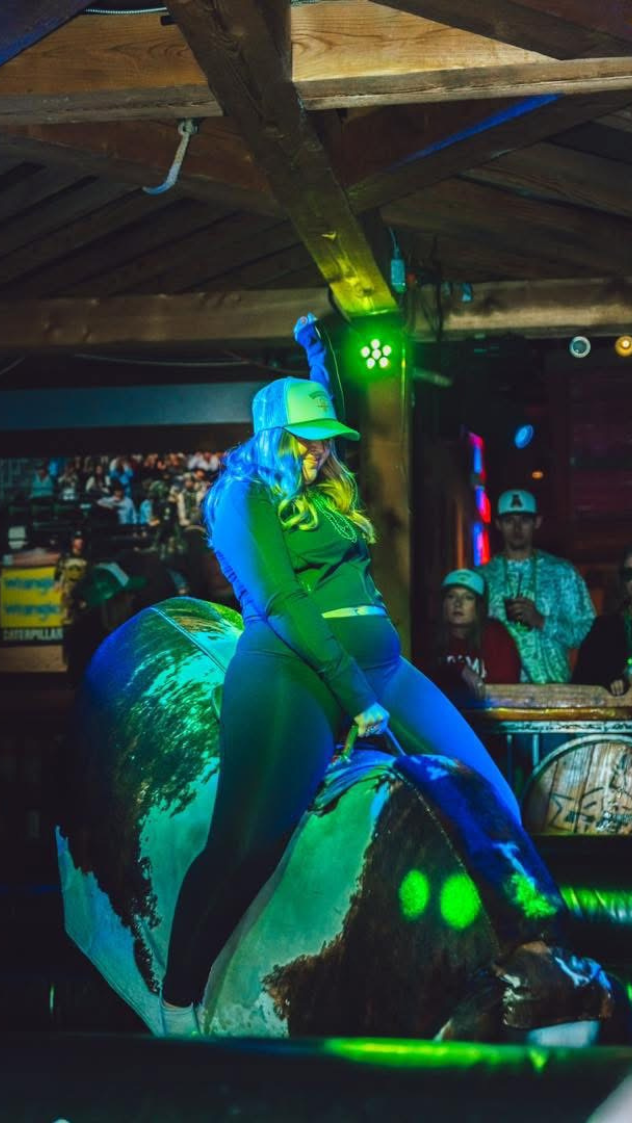 A woman riding the mechanical bull at PBR.