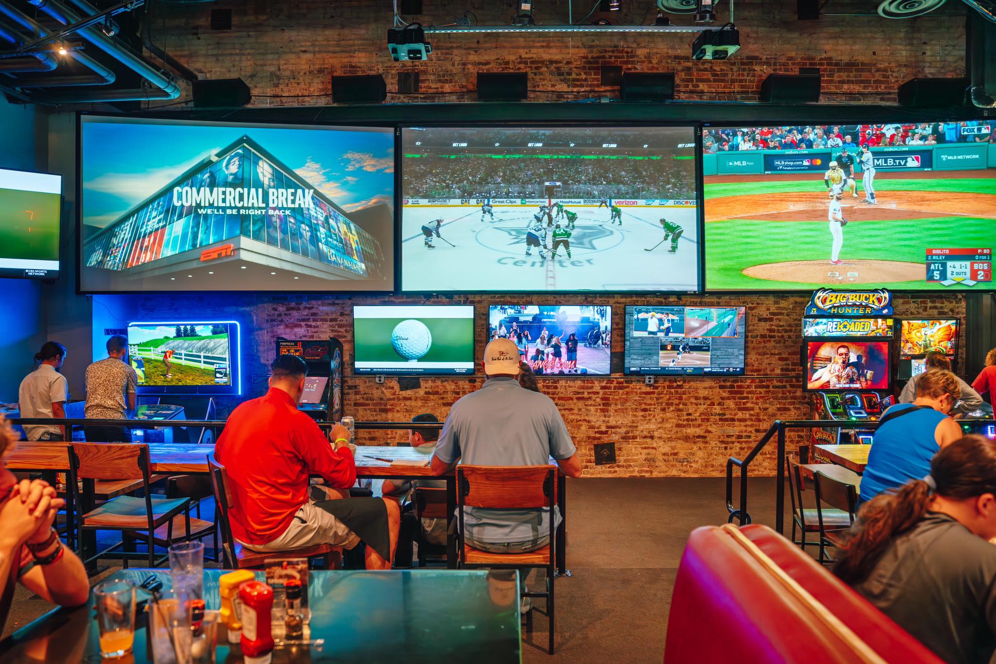 An image of sports being played not the big screens in the media room at Sports and Social.