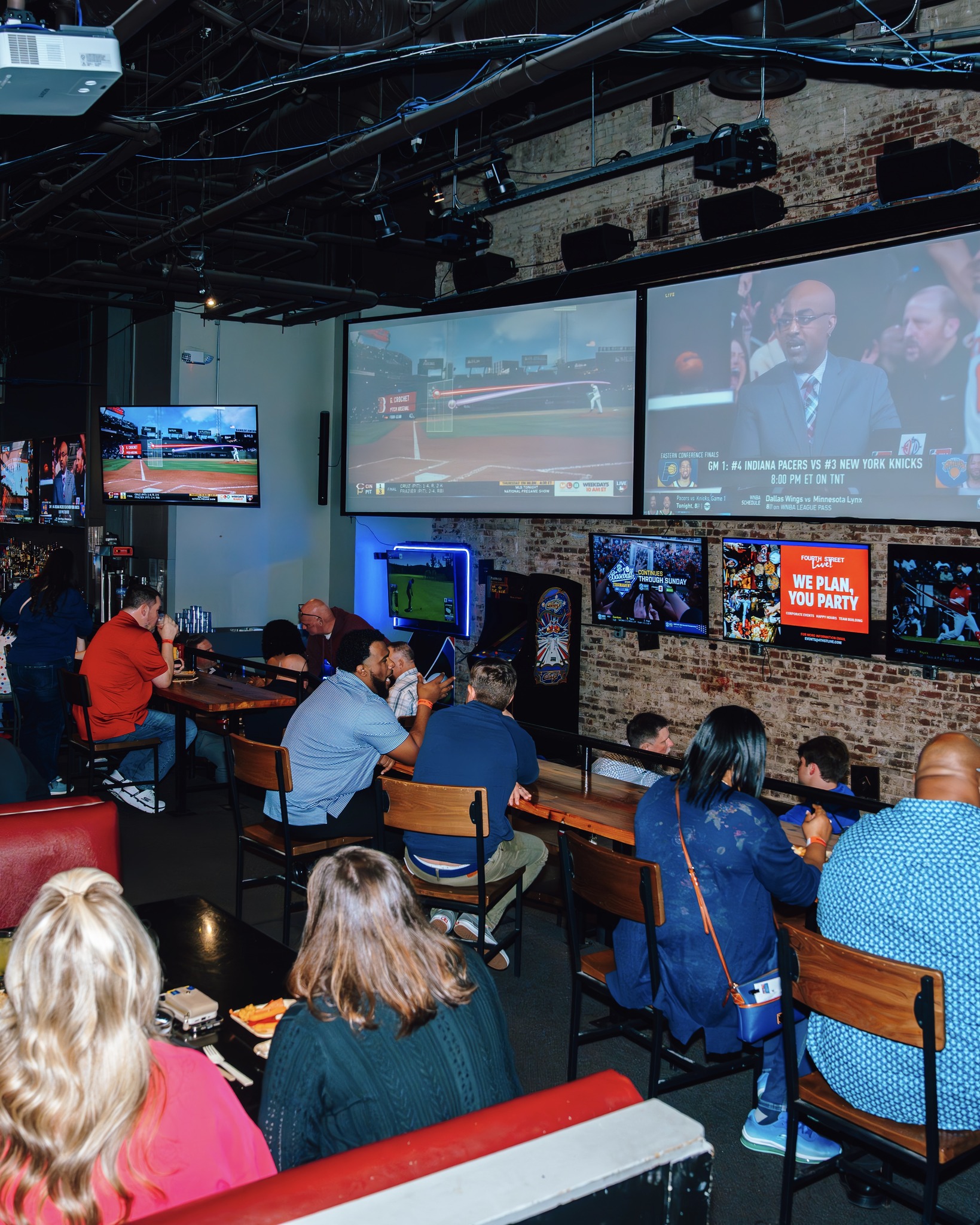 An image of sports being played on the big screens at Sports and Social.
