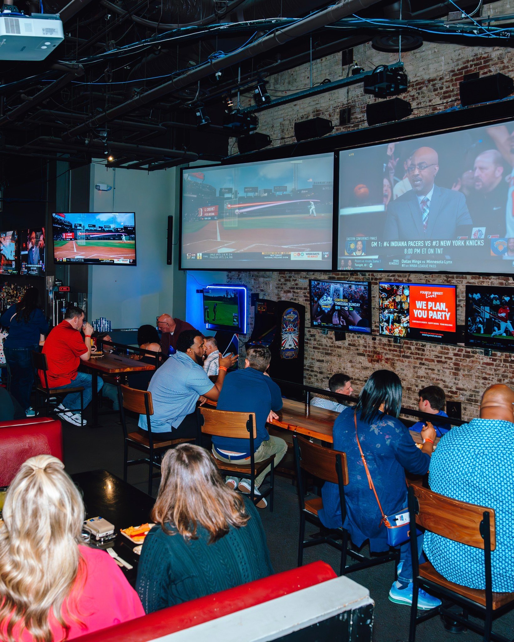 An image of sports being played on the big screens at Sports and Social.