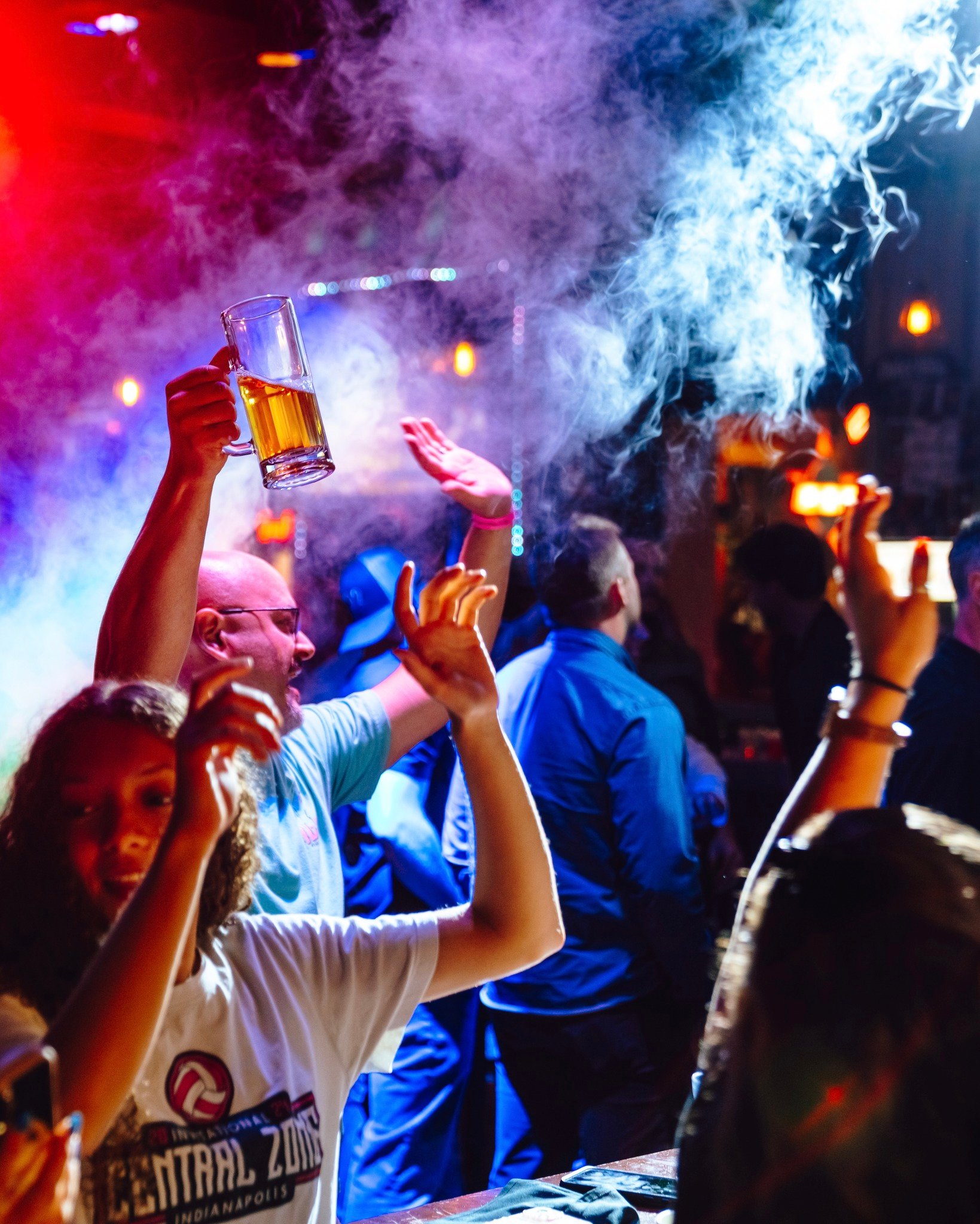 An image of people cheering with beers in hand and CO2 cannons going off.