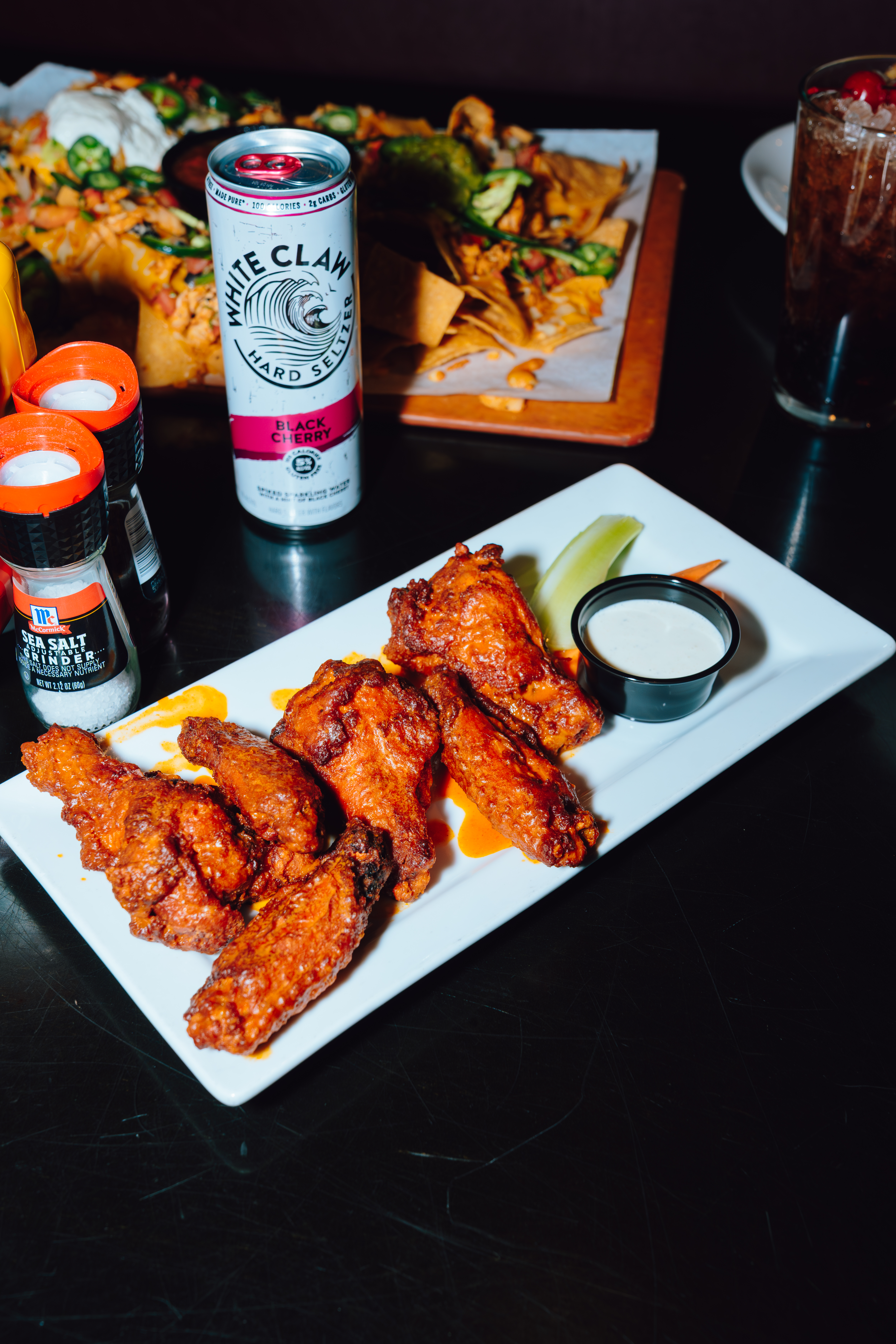 An image of wings, White Claw, and Loaded Nachos at Sports and Social.