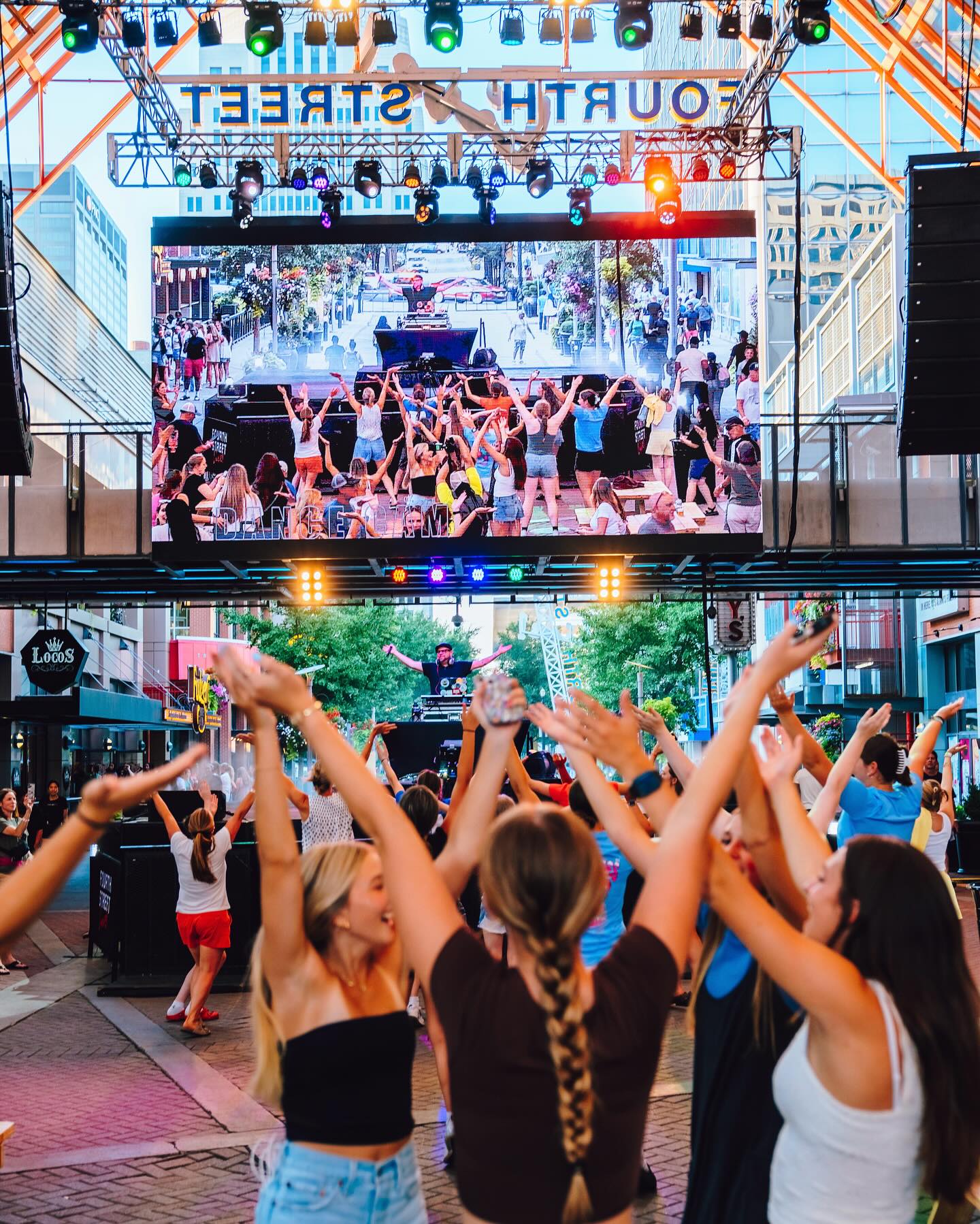 An image of a bunch of girls dancing with a dj playing live music.