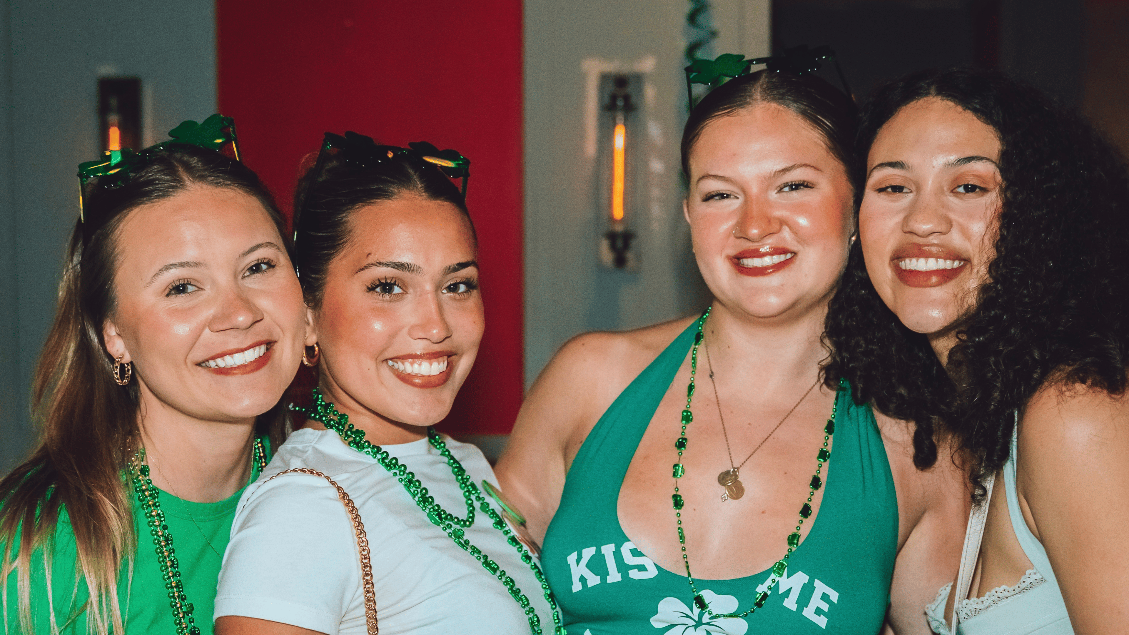 An image of 4 girls posing for a pic at shamrocks and Shenanigans.