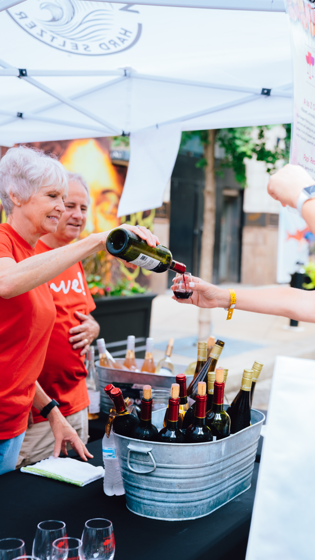 An image of a staff member pouring wine into a guests' glass.