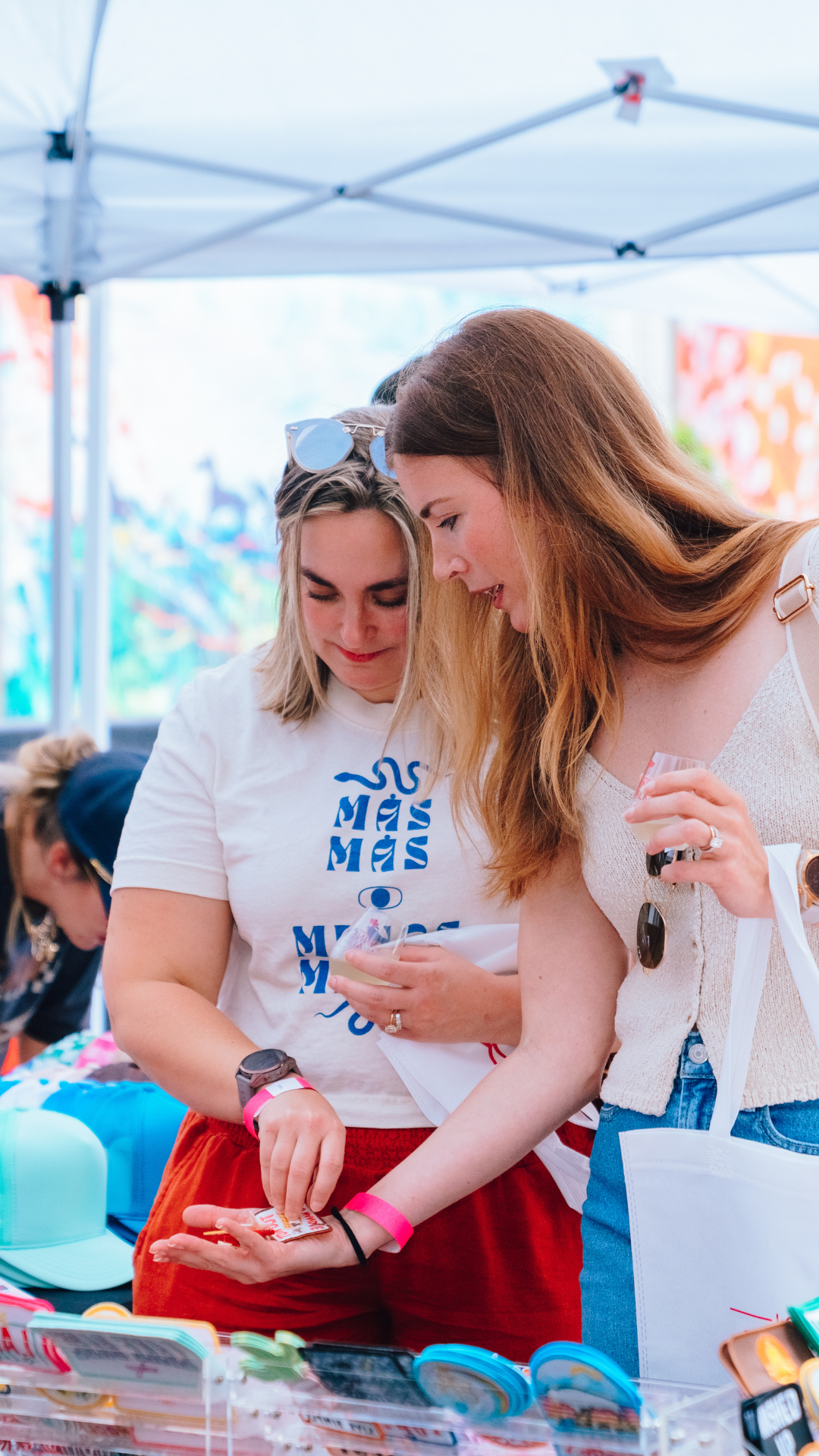 An image of two women shopping from a vendor at Wine Walk.