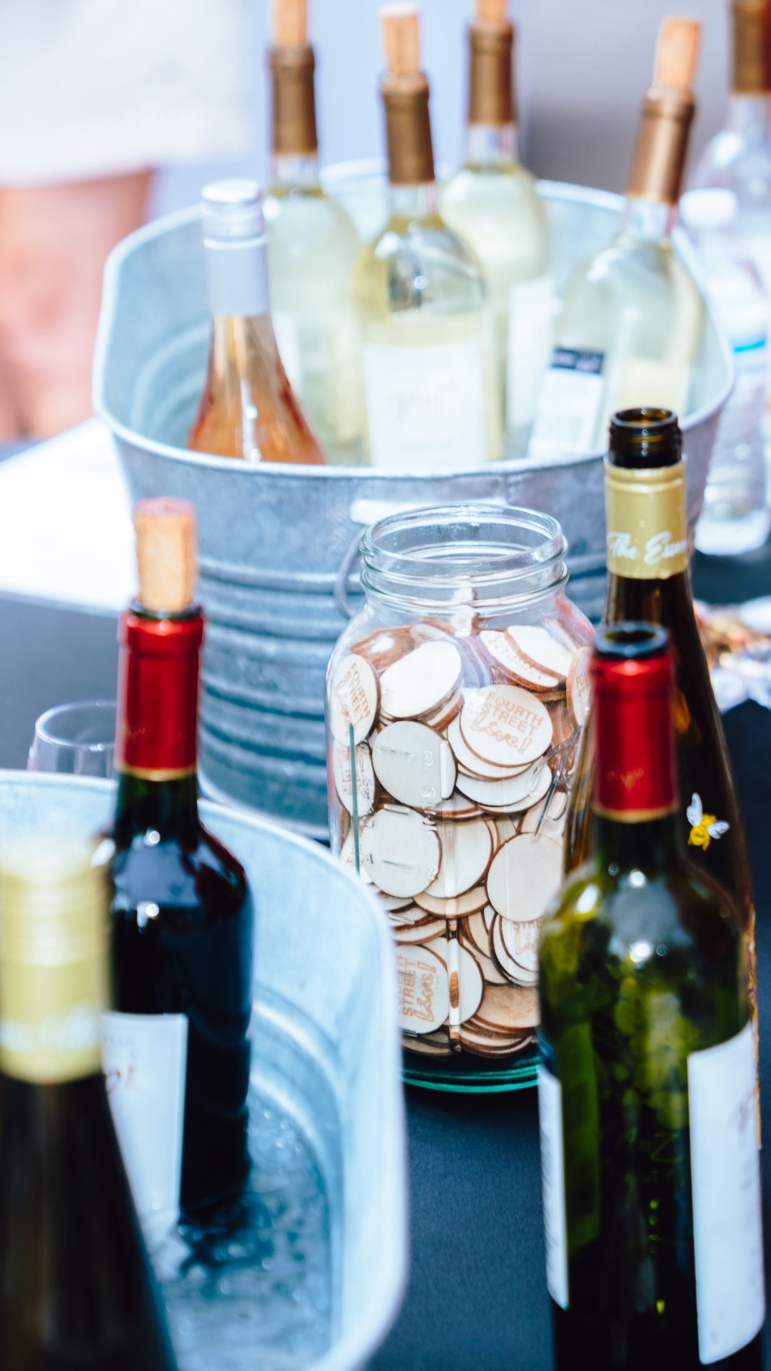 An image of wine bottles and a jar of tokens.