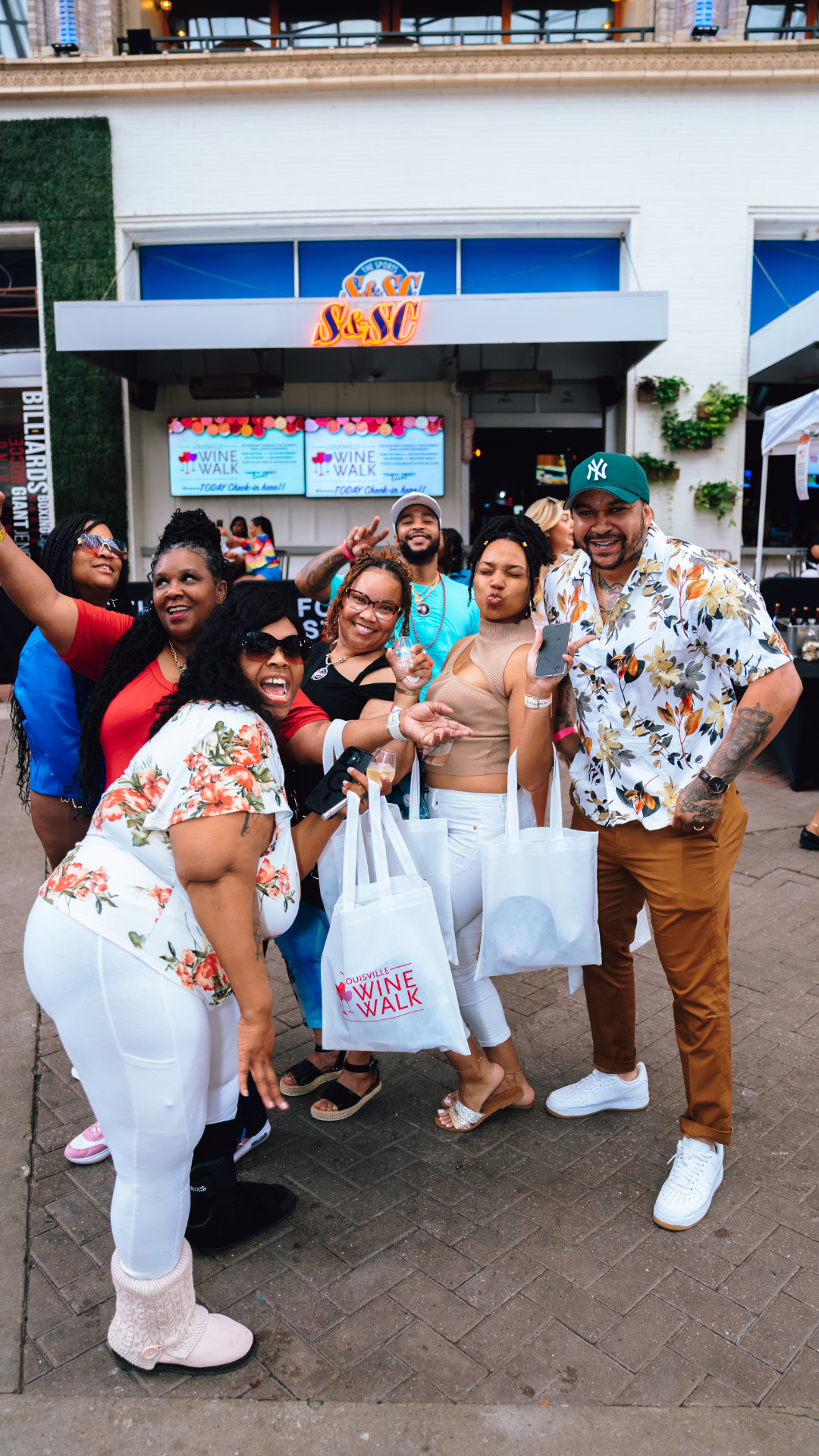 An image of ladies and men posing for a pic at Wine Walk.