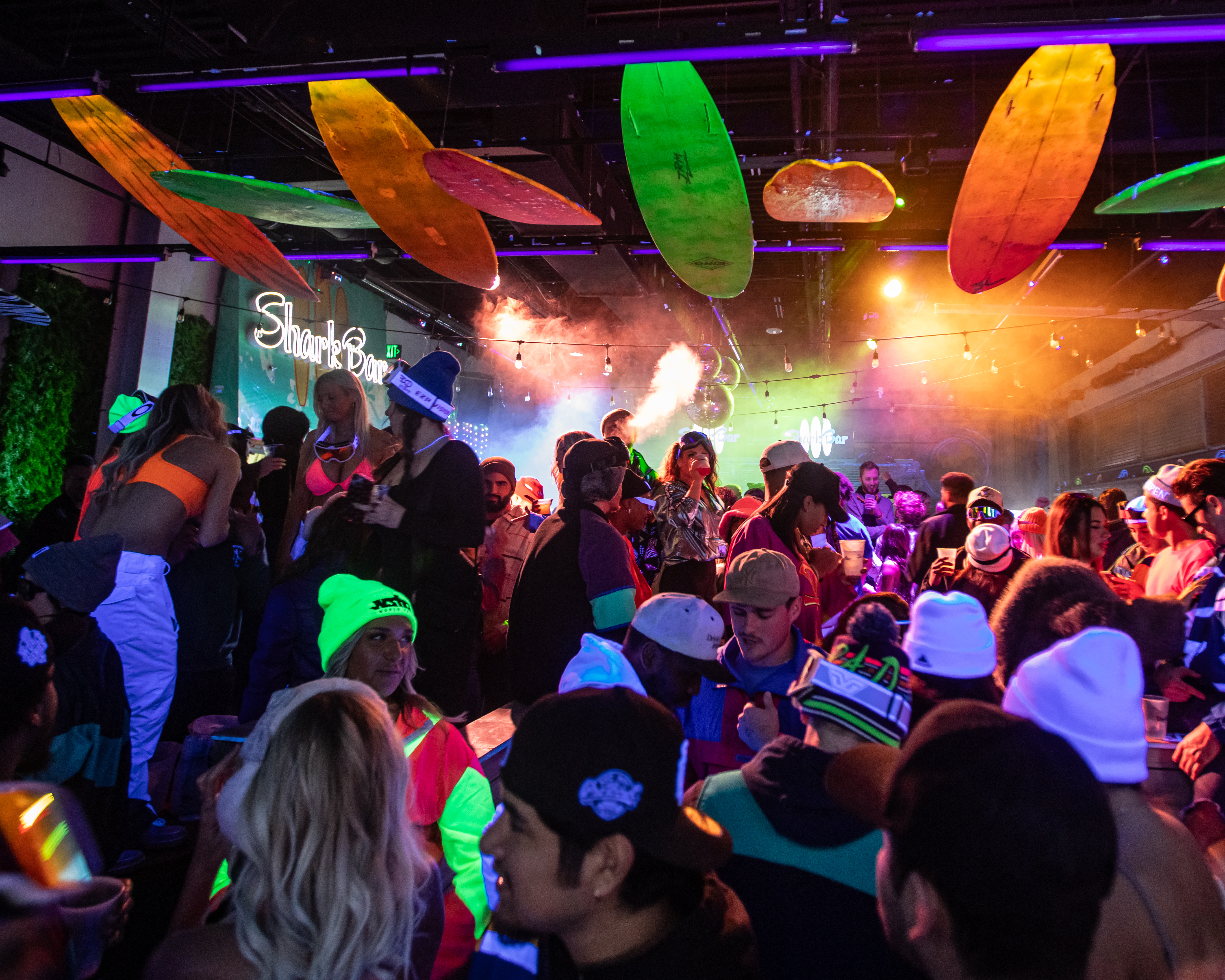 Packed room at Shark Bar, guests in ski apparel and club lights in background