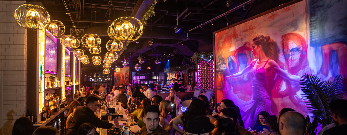 Lively crowd at Bezos y Abrazos bar in the evening.