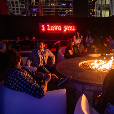 Guests enjoying the outdoor fire pit and patio at night at Mosaic in the Power & Light District, Kansas City, MO. 