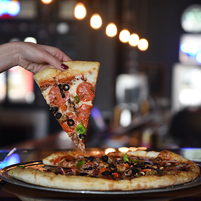 Pizza Bar - hand picking up a piece of pizza
