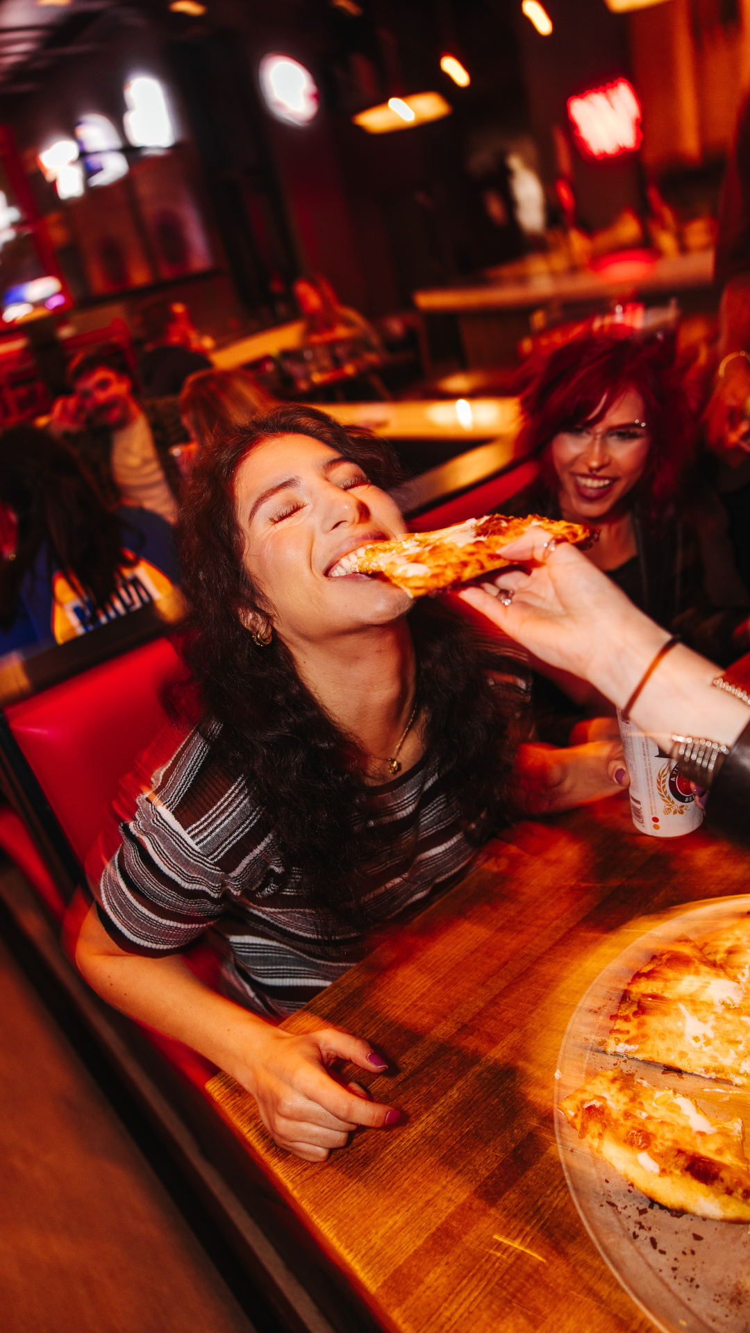 Woman eating pizza at Pizza Bar
