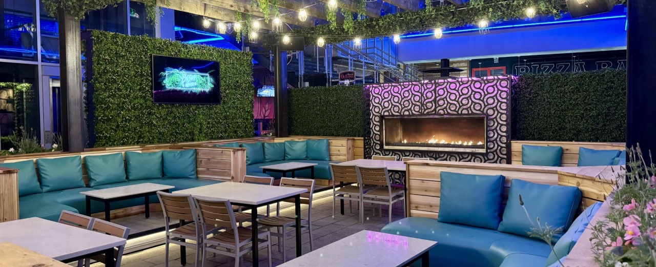 Outdoor table and lounge seating with fireplace at Besos y Abrazos.