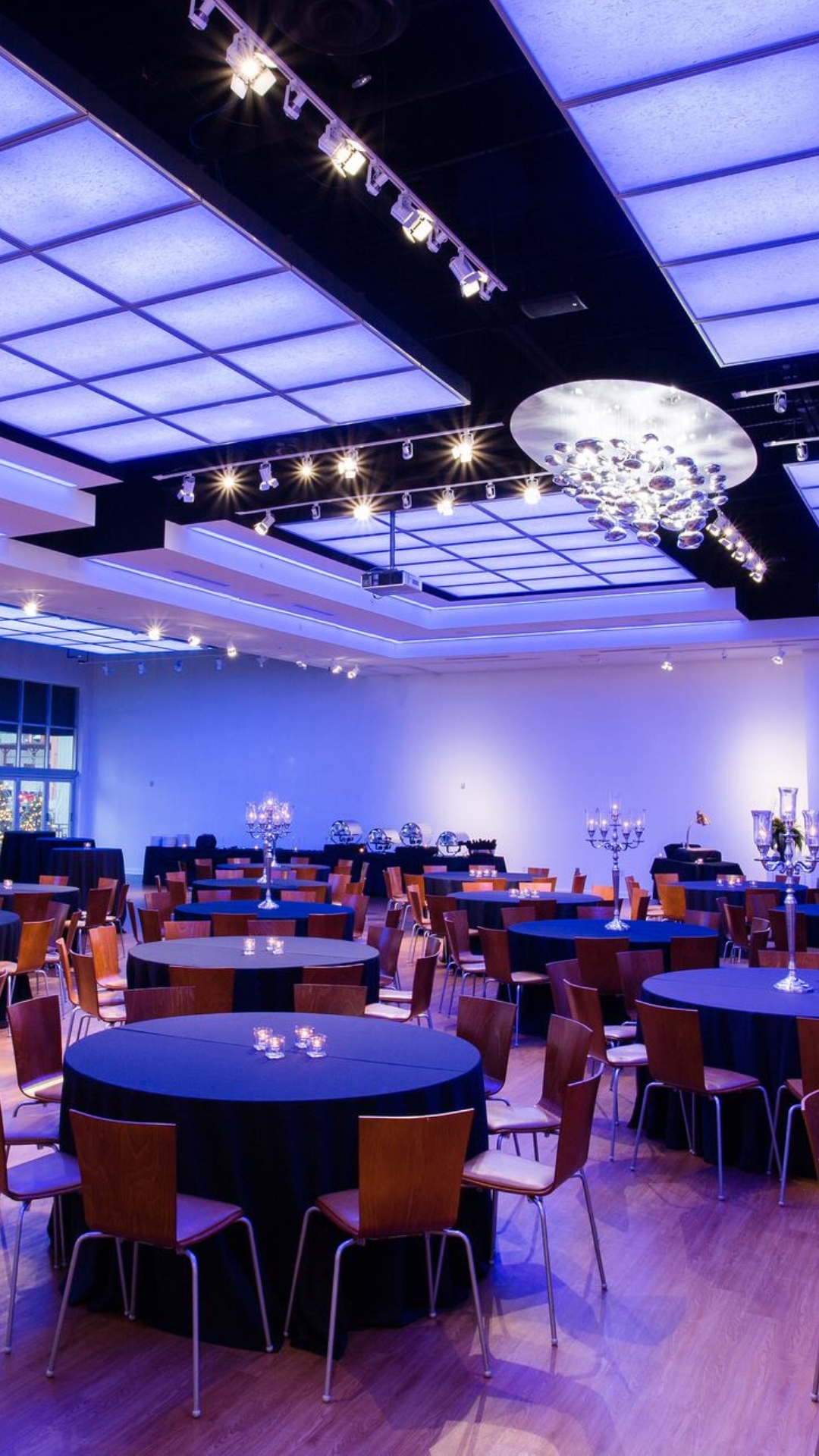 The Gallery Event Space with set tables and blue LED ceiling lights.