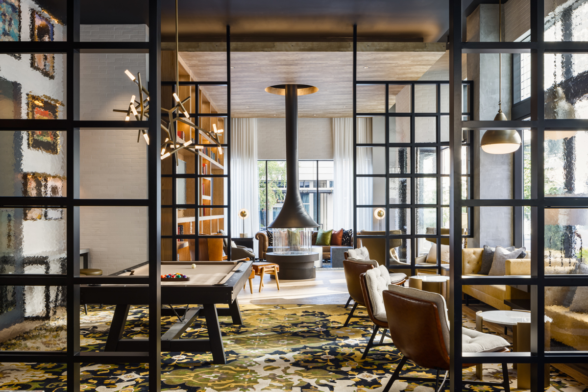 Stylish common space lounge featuring seating and central fireplace in luxury Midland Lofts building.