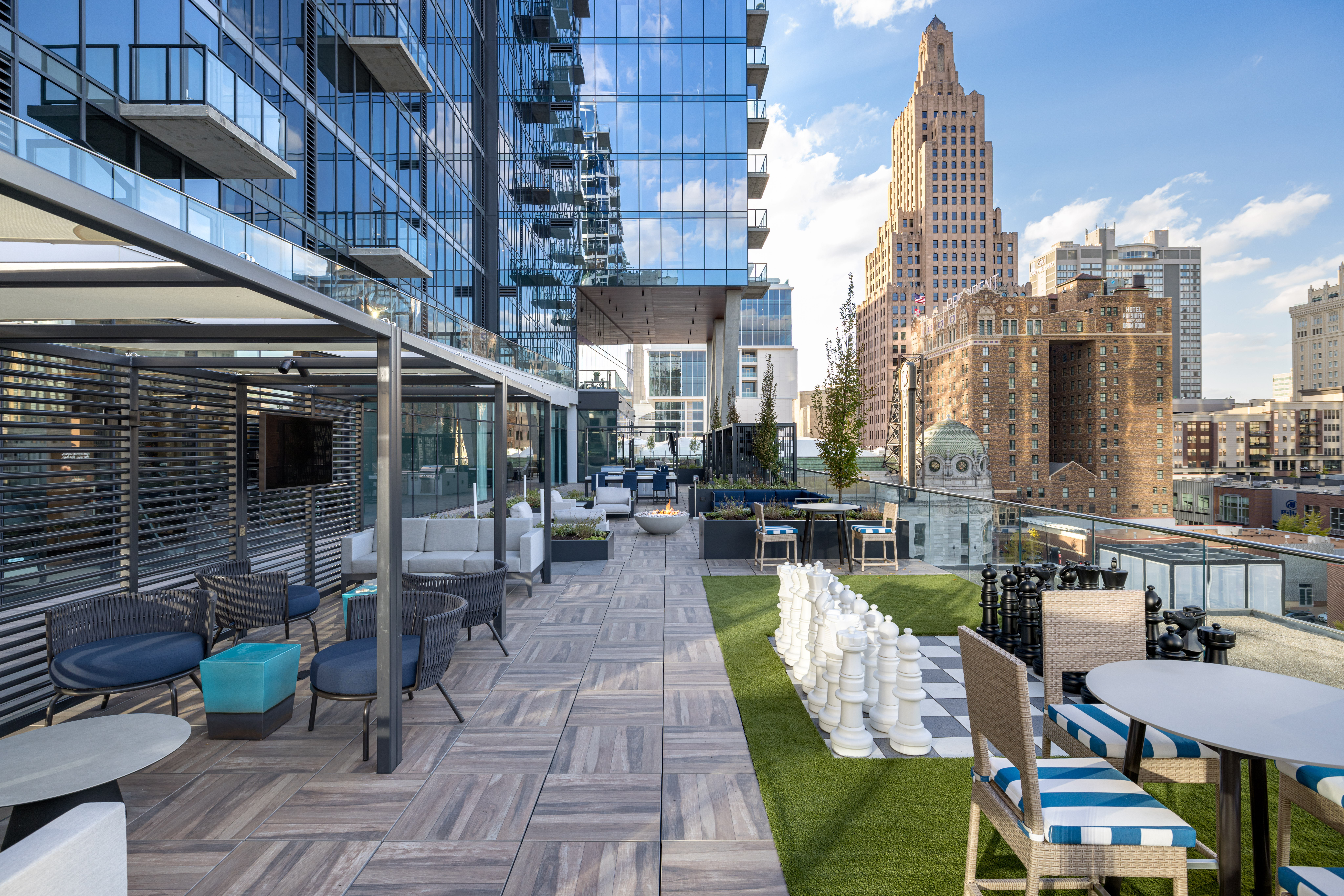Patio featuring covered area, oversized lawn games, and seating at Three Light luxury apartment building in Kansas City, MO.