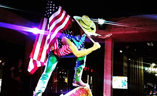 Bull rider on mechanical bull with flag